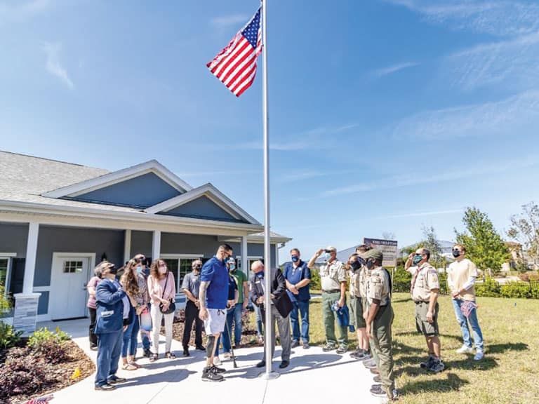 Stephen Peterson with a Group of People Around a Flag Pole