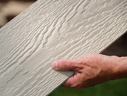 Close Up of a Man Holding Fiberboard Siding